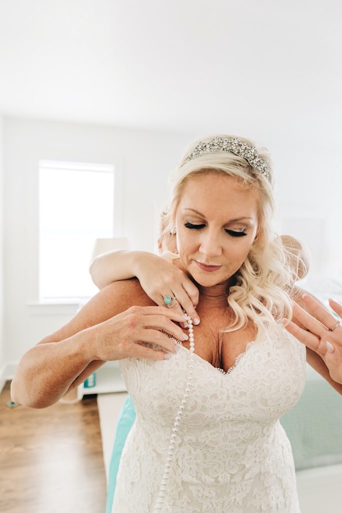 bride putting on her jewelry