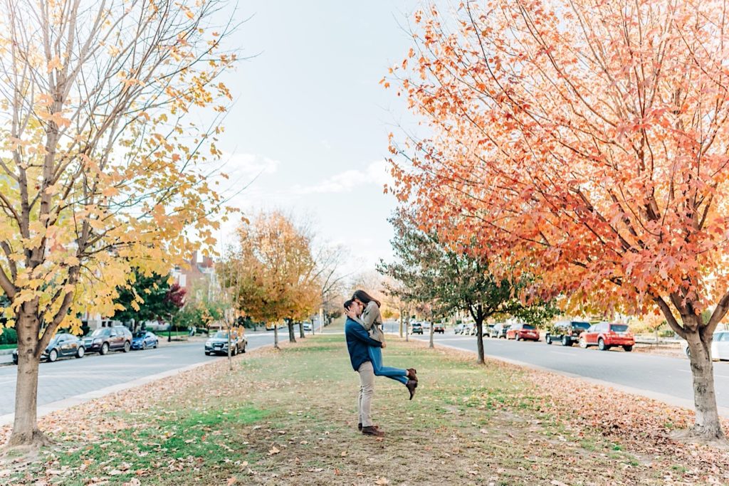 guy carrying girl between fall leaves in Richmond
