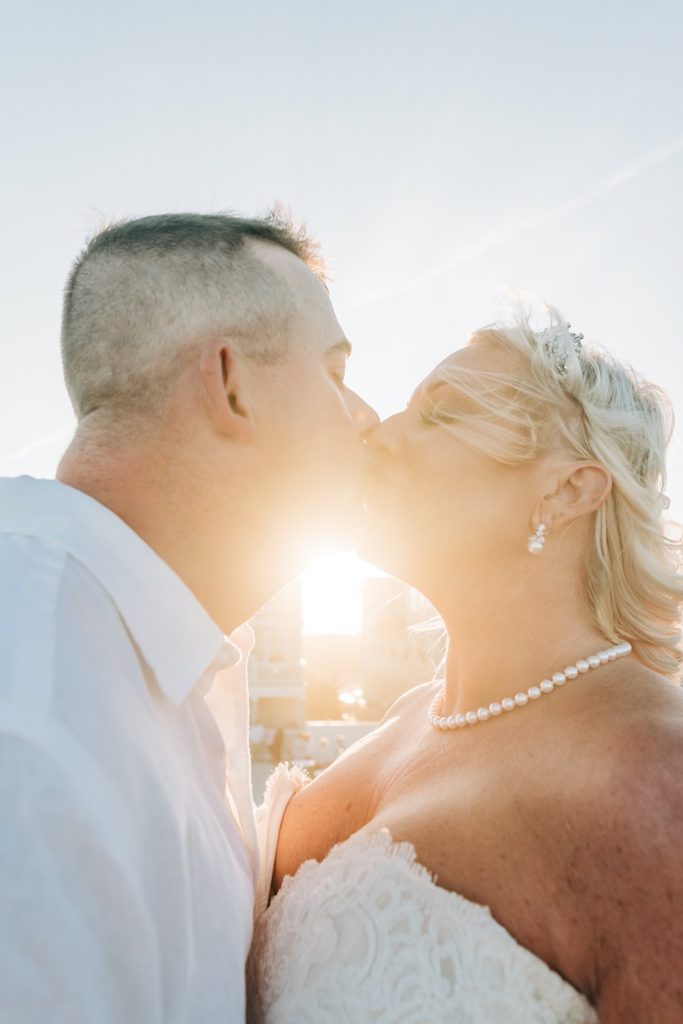 bride and groom kissing as the sun hits them