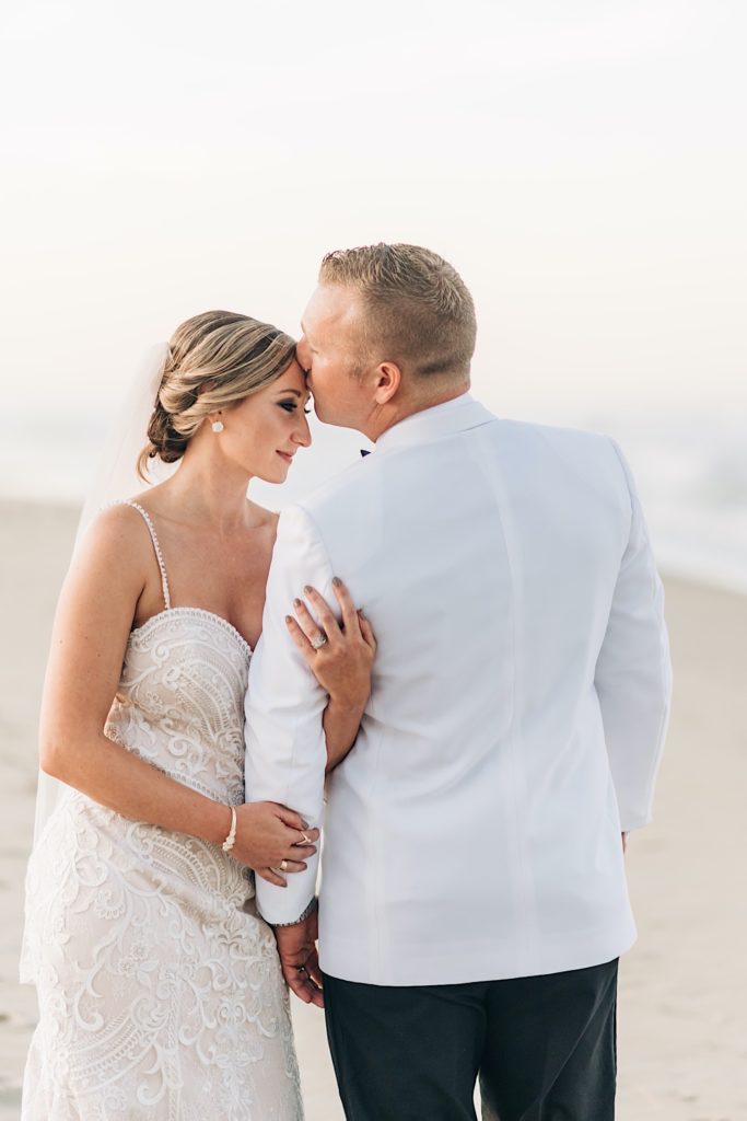 Bride and groom snuggling on the beach in obx