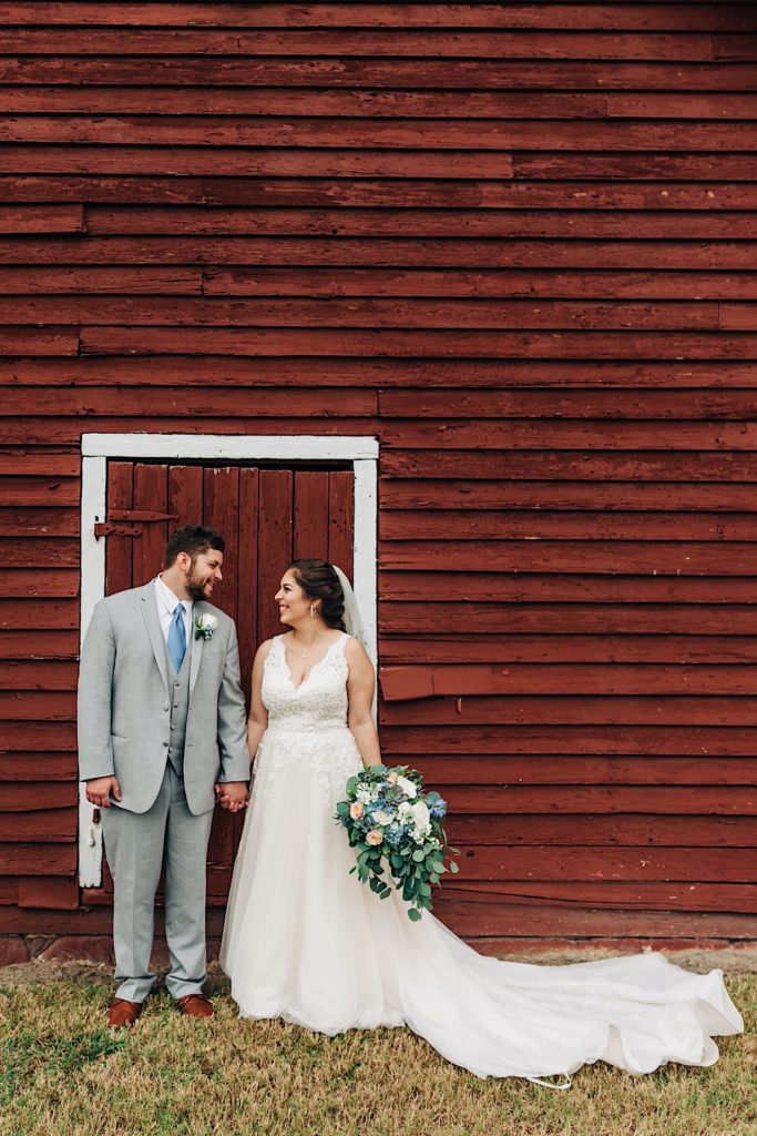 bride and groom infront of a red barn