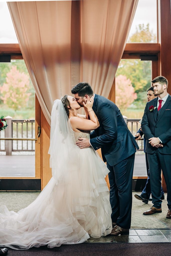 bride and grooms first kiss at welch allyn wedding