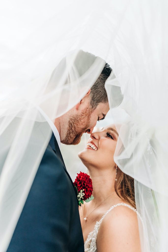 bride and groom under brides veil 