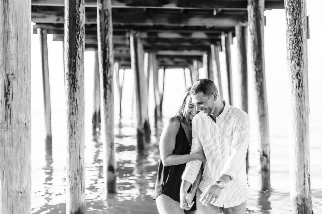 couple walking under pier in Virginia Beach