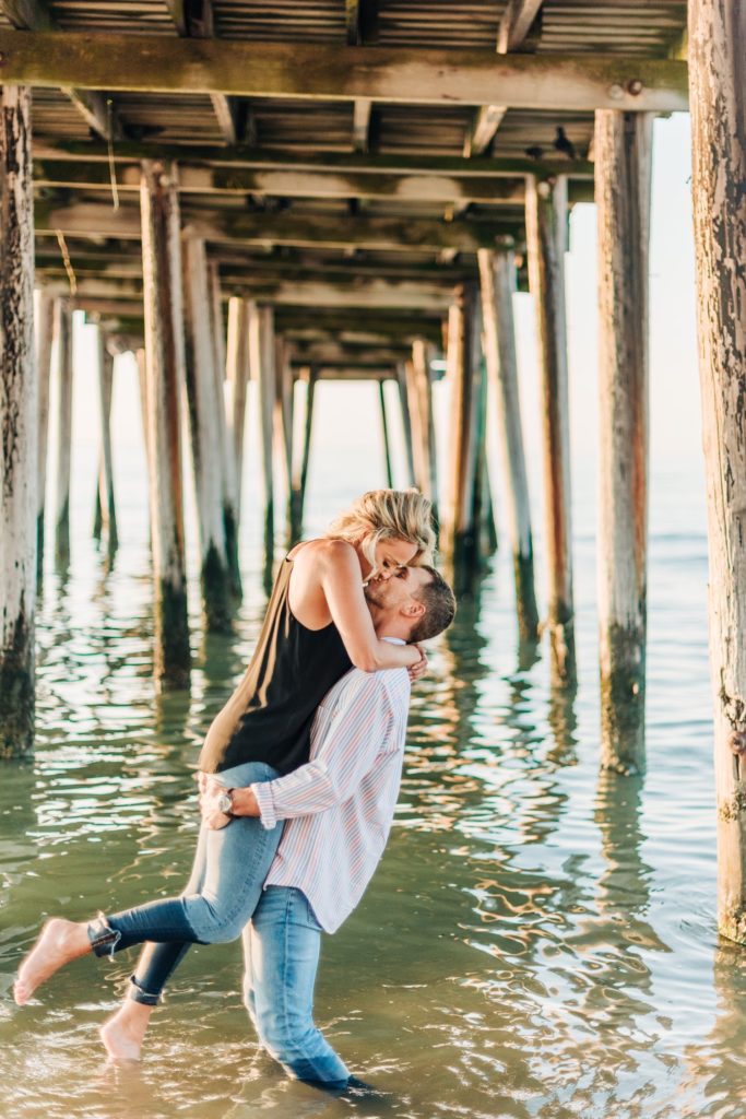 couple kissing under pier in Virginia Beach