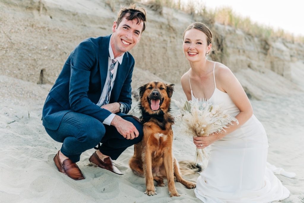 Bride and groom on the beach with their dog at outer banks intimate wedding