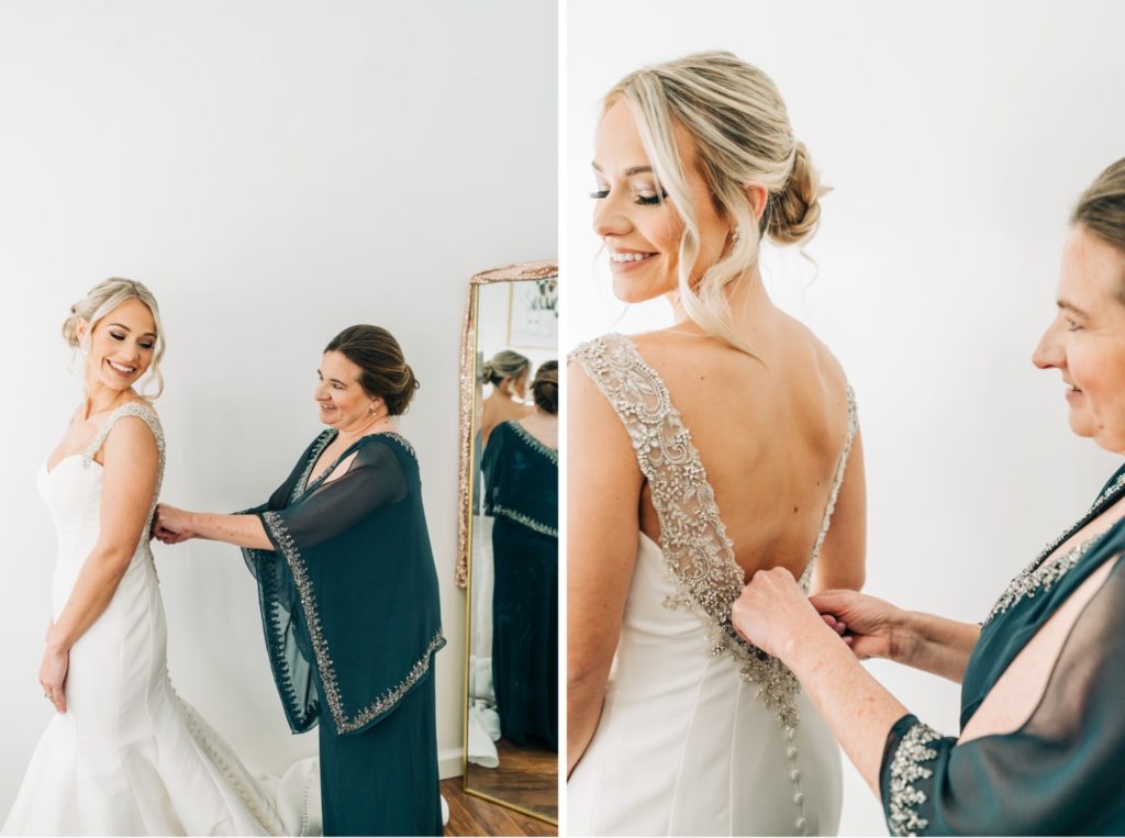 bride and mother putting on dress