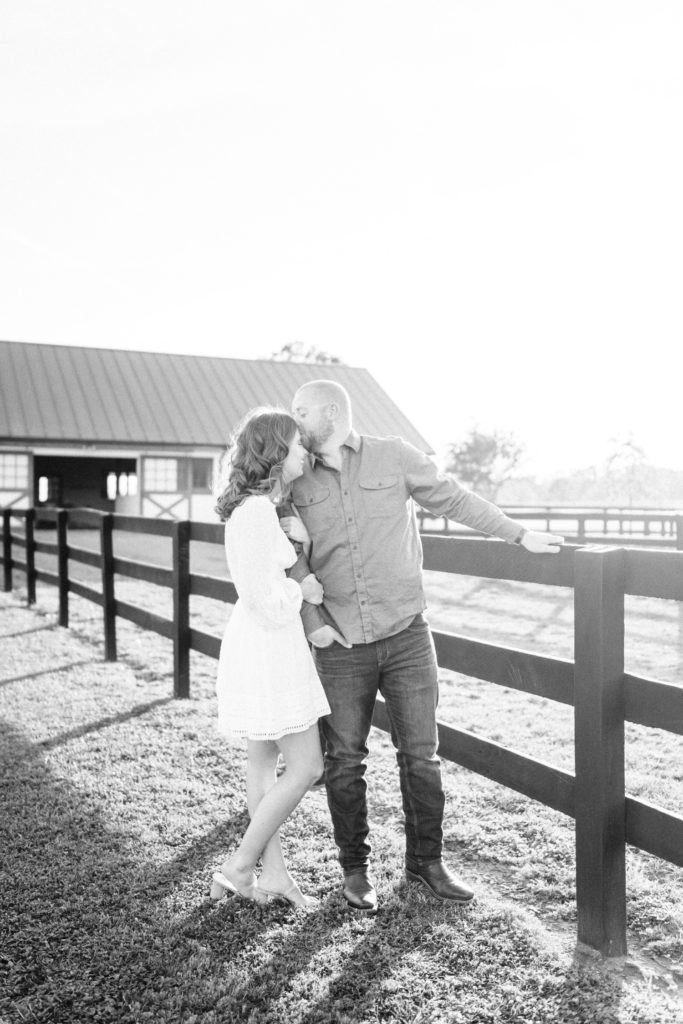 guy kissing girl on forehead infant of barn