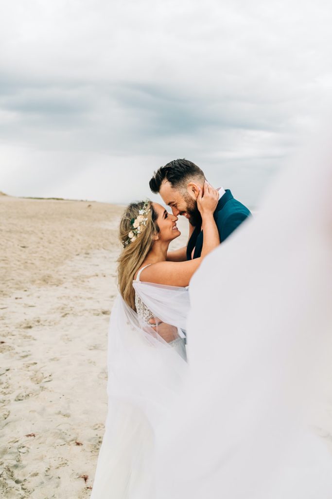 bride and groom kissing the beach in Chincoteague