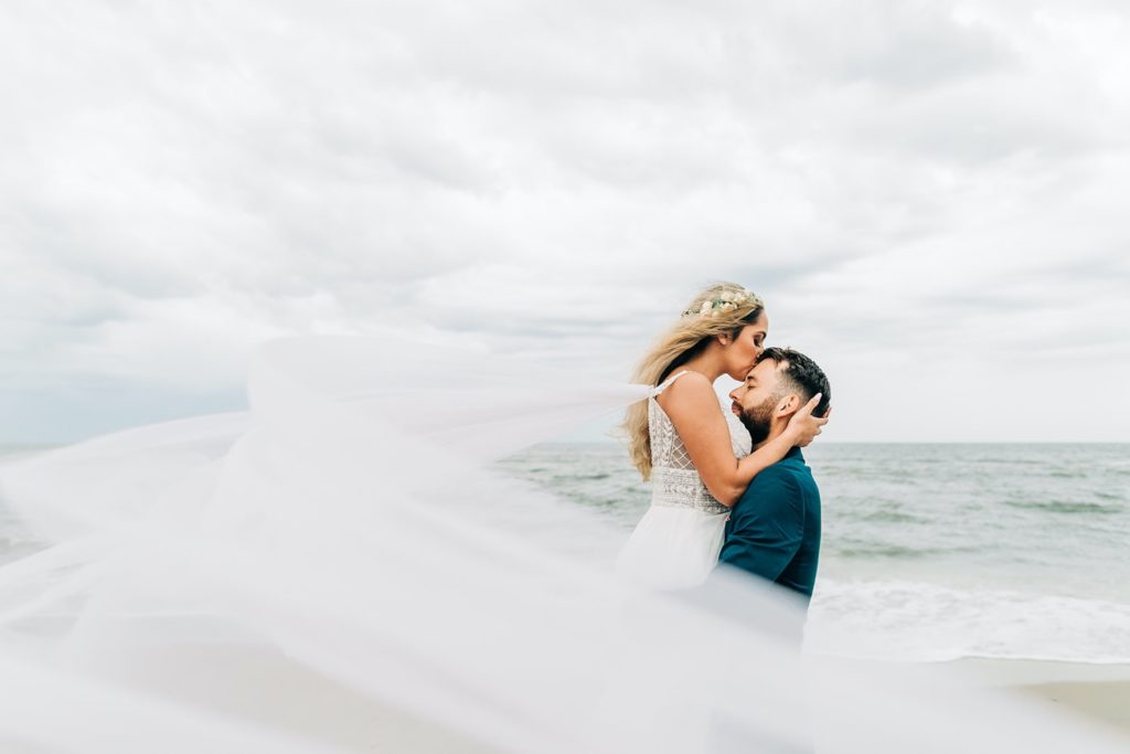 bride and groom kissing the beach in Chincoteague