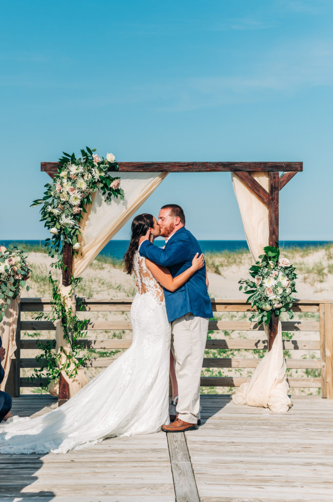 Bride and groom kissing at the altar on beach