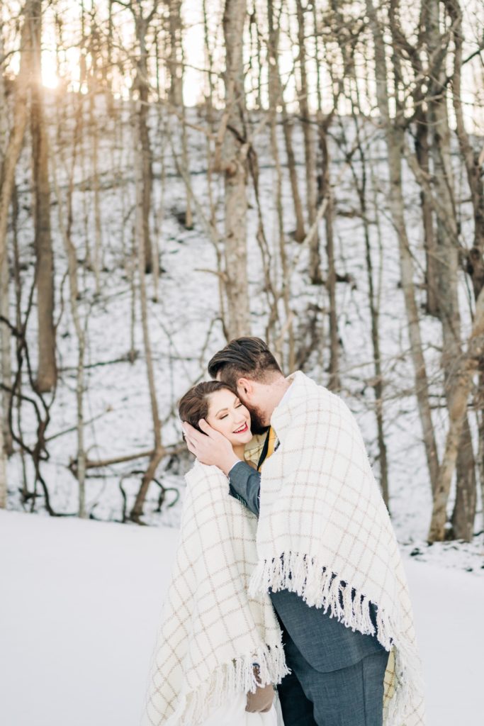 bride and groom snuggling in the snow at Irvine estate
