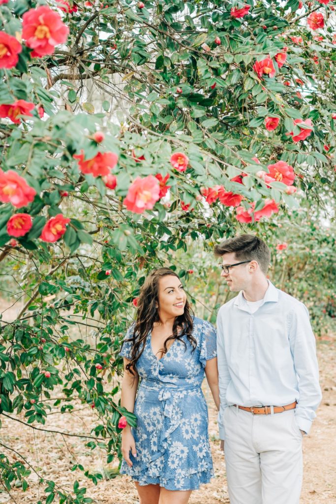 Couple walking through flowers at Botanical Gardens for engagement photos in VA