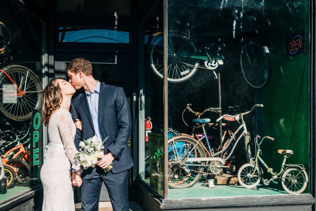 Bride and groom posing outside of bike shop after their Chesterfield Courthouse Elopement