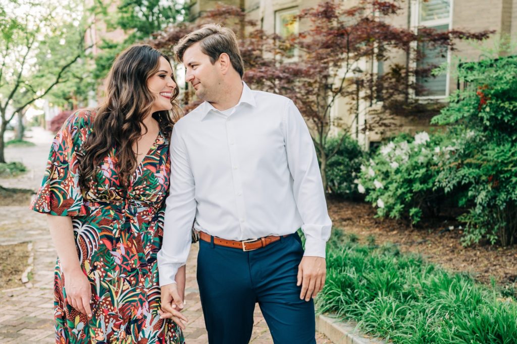 Couple holding hands and walking down street for their Virginia Beach Engagement Portraits