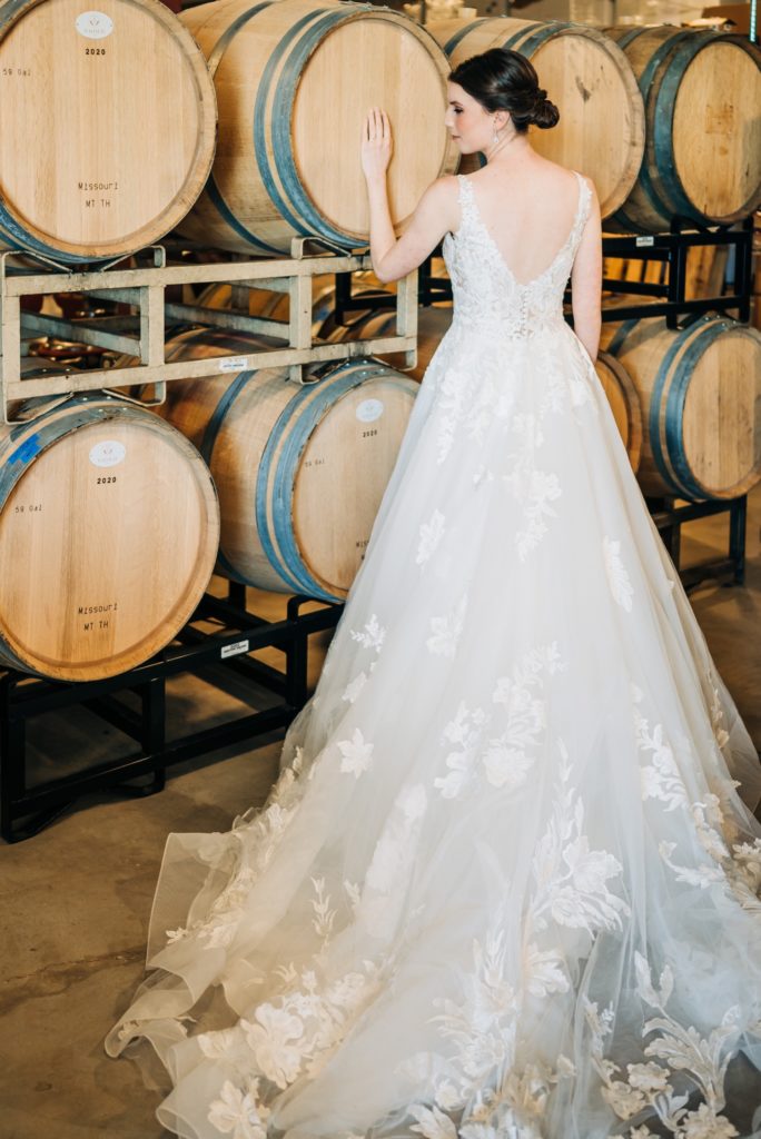 bride in front of wine barrels at windridge vineyards