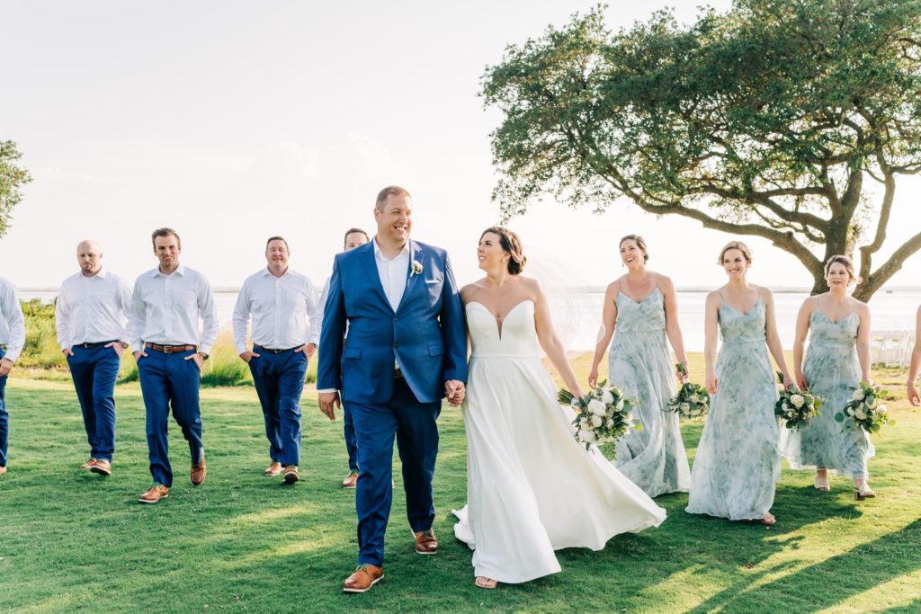 Bride and groom walking together with bridal party following behind them at Currituck Country Club  wedding