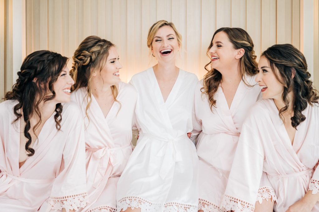 Bride laughing with bridesmaids as they are getting ready before the Hermitage Museum wedding in Norfolk VA