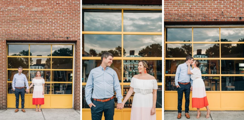 Couple posing hand in hand in front of brick building