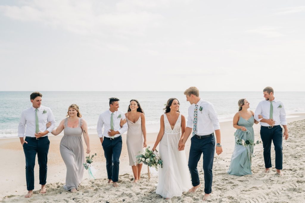 Entire bridal party walking down the beach at Hatteras OBX wedding