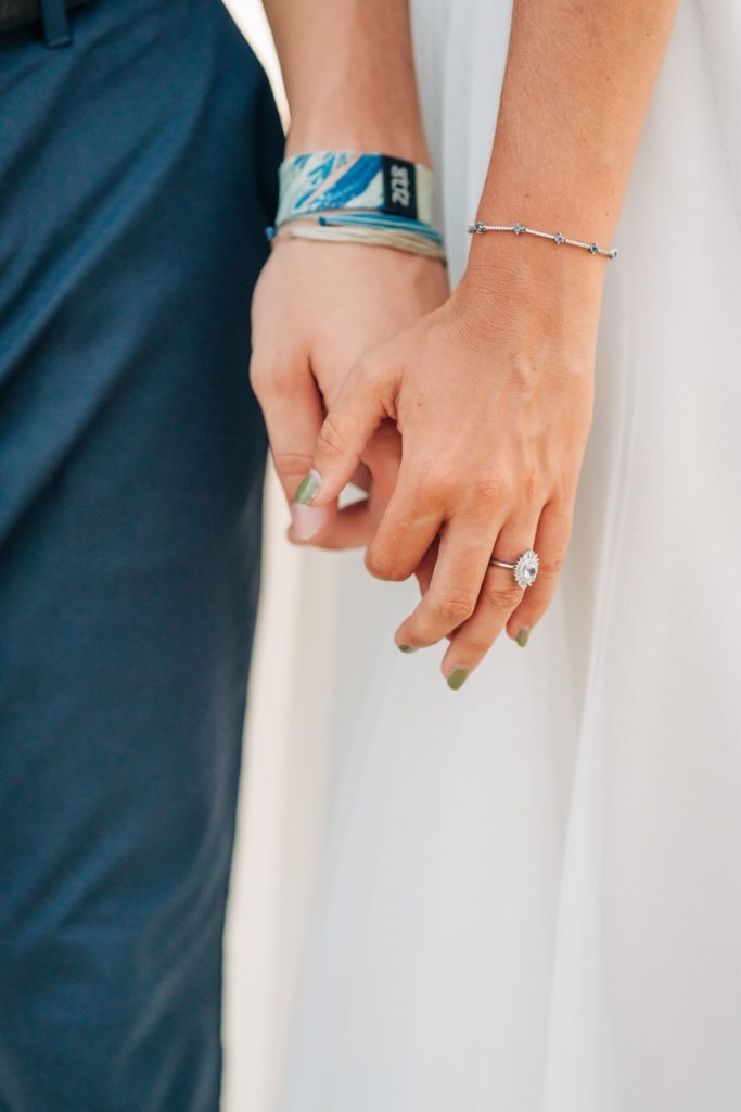 Closeup of bride and groom holding hands