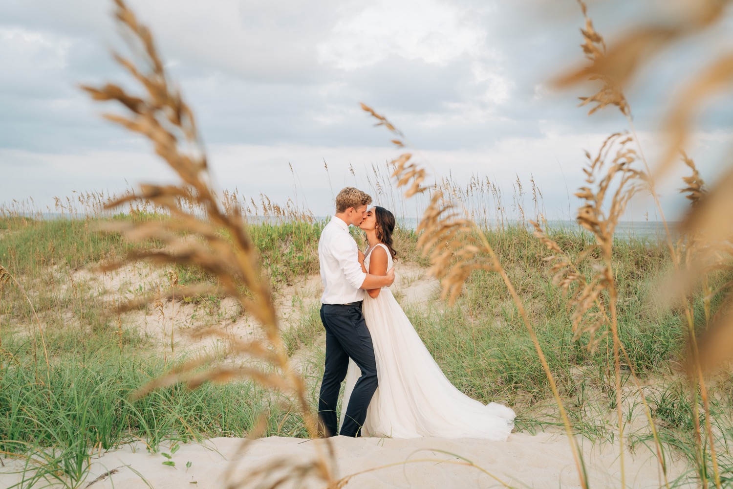 Bride and groom kissing on the sand at Hatteras OBX wedding
