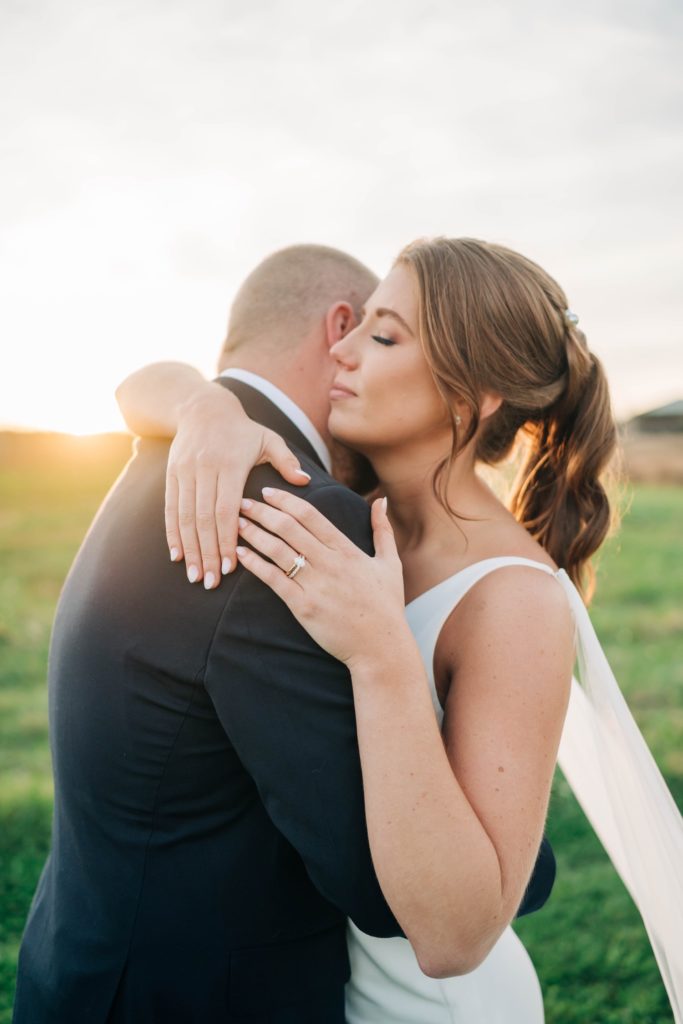 Bride and groom hugging at sunset