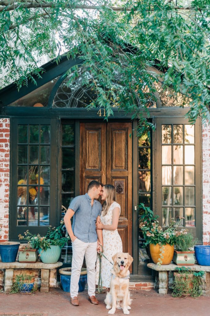 couple kissing infront of green house