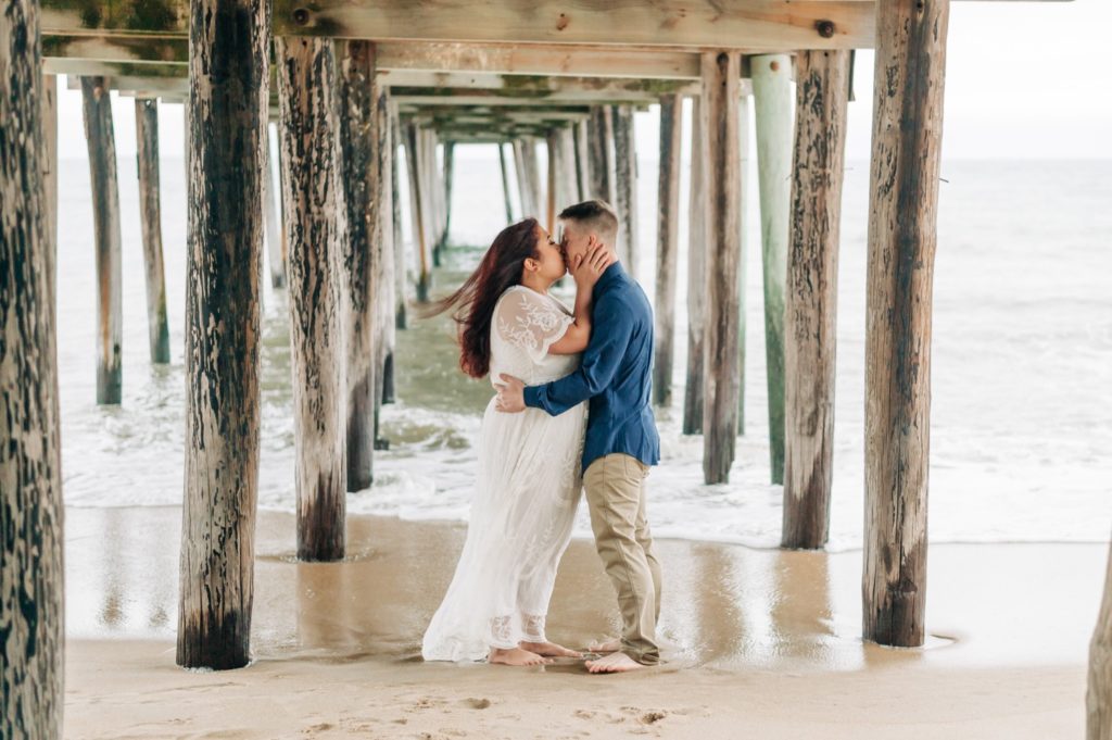 couple kissing under Virginia pier