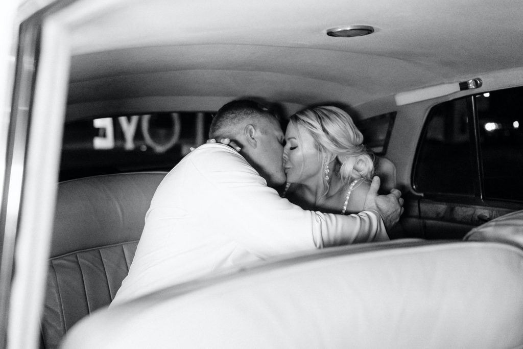 couple kissing in the back of vintage rolls Royce