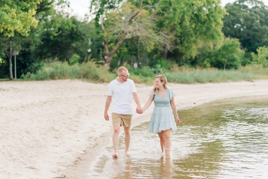 engaged couple in Yorktown walking in water for their Yorktown engagement portraits