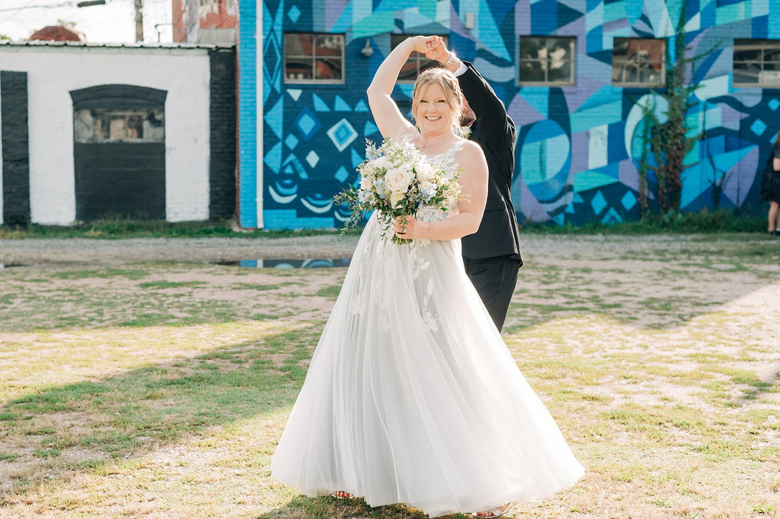 Couple twirls in front of murals for Intimate Fan District Wedding in Richmond