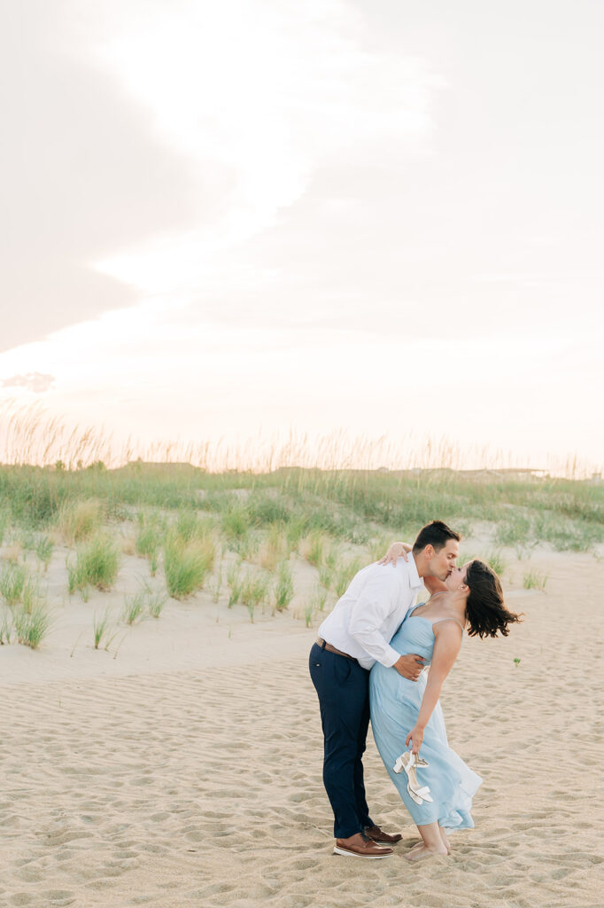 Couple kissing by the dunes in Virginia Beach