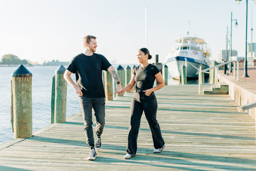 Couple walking near ships in Norfolk 