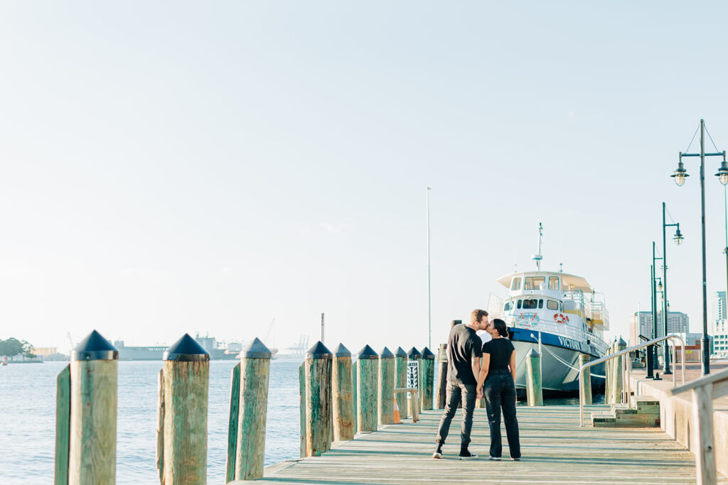 A couple kissing by the boats at the Norfolk waterside