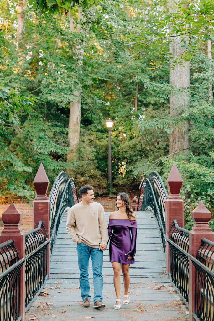 couple holding hands on bridge