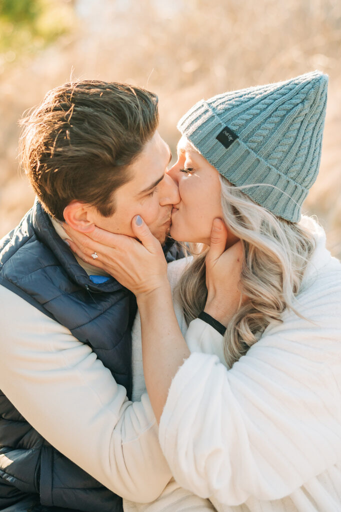 girl wearing green hat and kissing fiancé