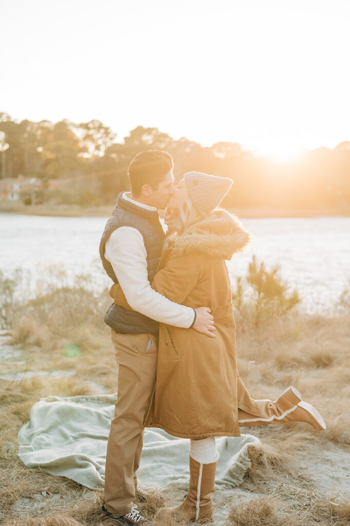 couple dressed for winter kissing on the beach