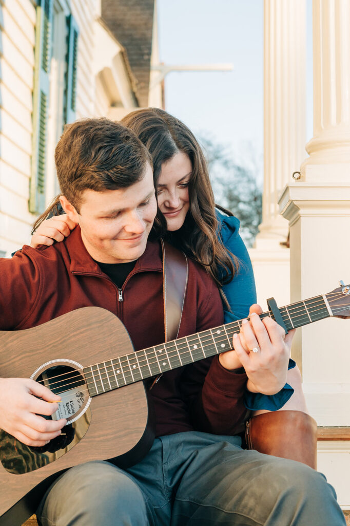 couple embracing while playing guitar