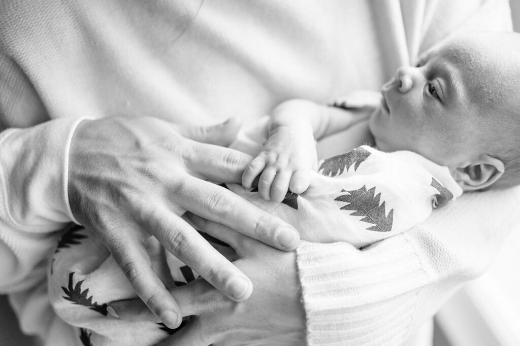 tiny baby holding finger