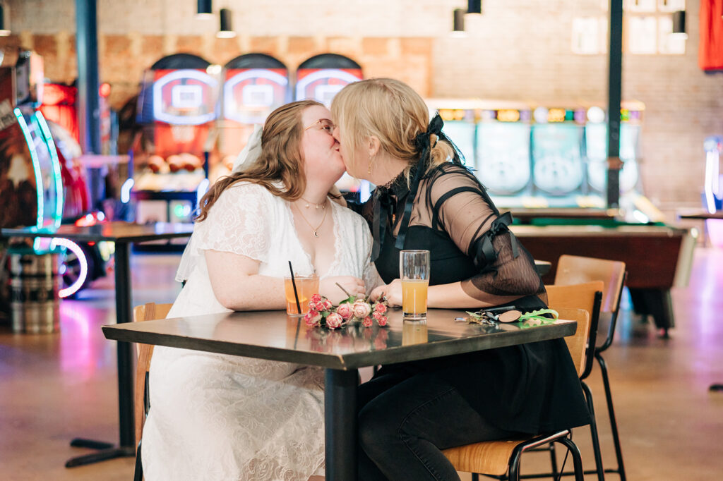 couple kissing at high top table