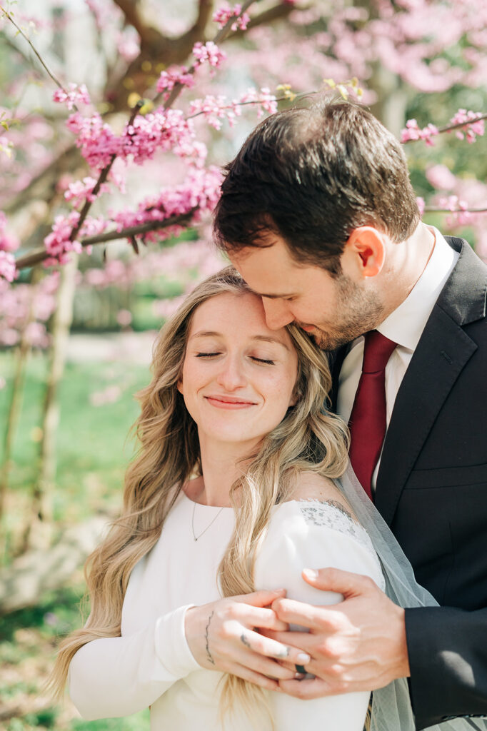 couple embraces by tree