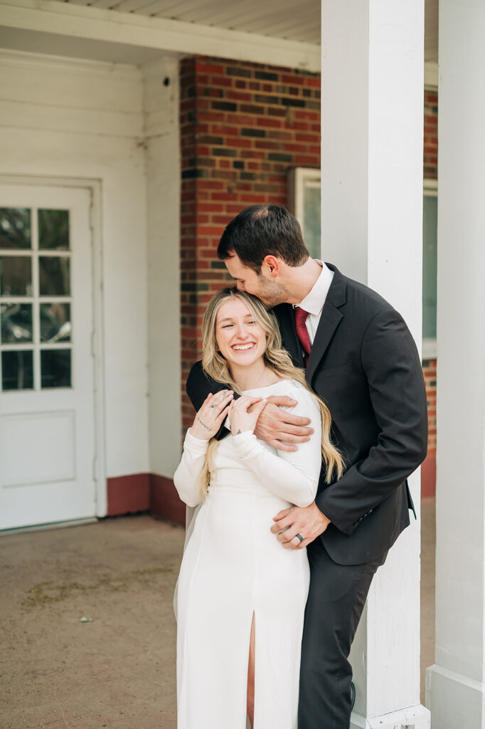 groom wearing a black suit and red tie