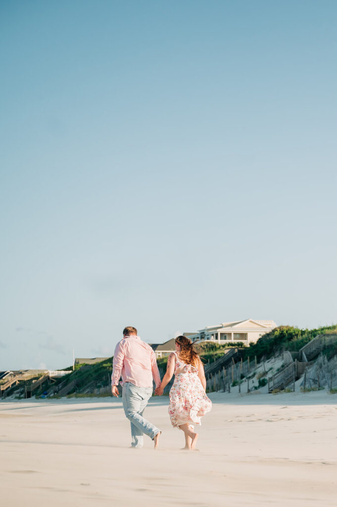couple walks on beach before proposal