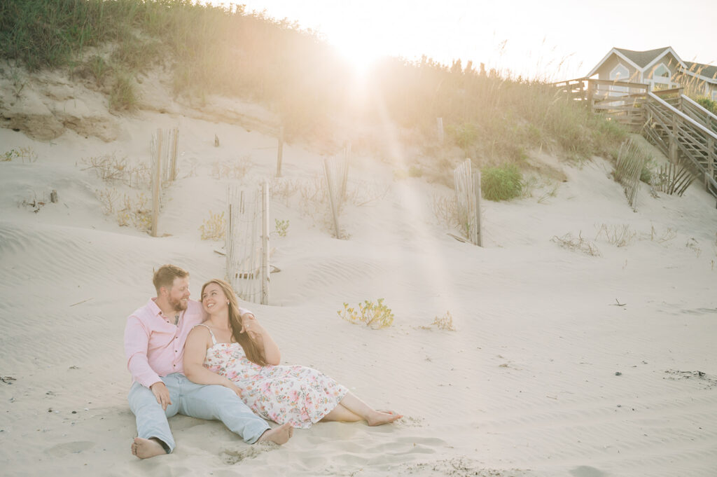 couple sits on beach after proposal