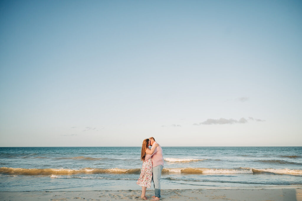 couple kisses along water