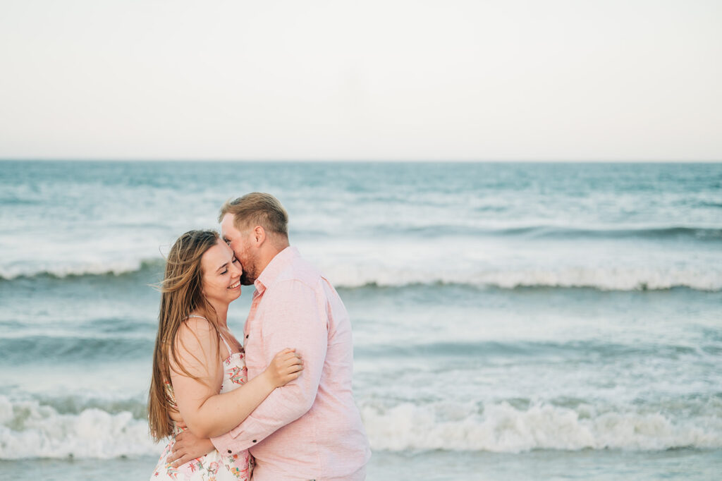 couple kisses along water