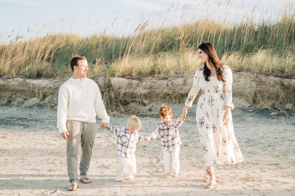 couple laughing and hold sons hands