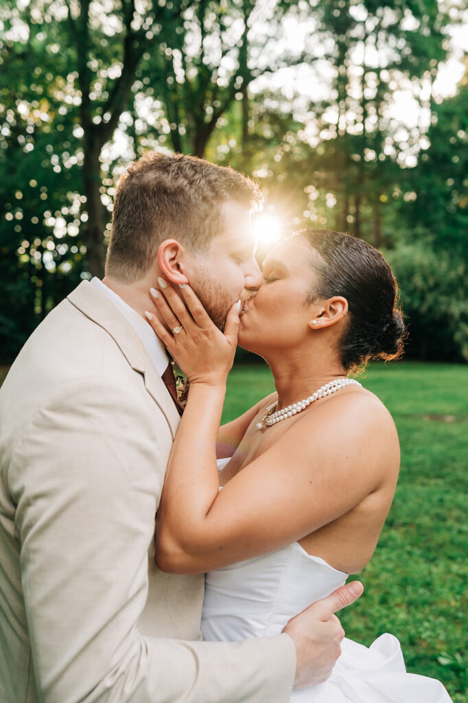 bride and groom kissing under the sun
