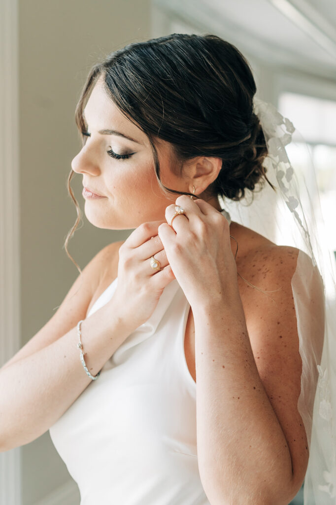 bride putting on earrings
